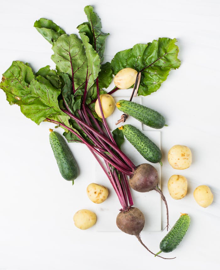 Mastering the First Impression: Your intriguing post title goes here Assorted organic vegetables including beets, cucumbers, and potatoes on a white surface.